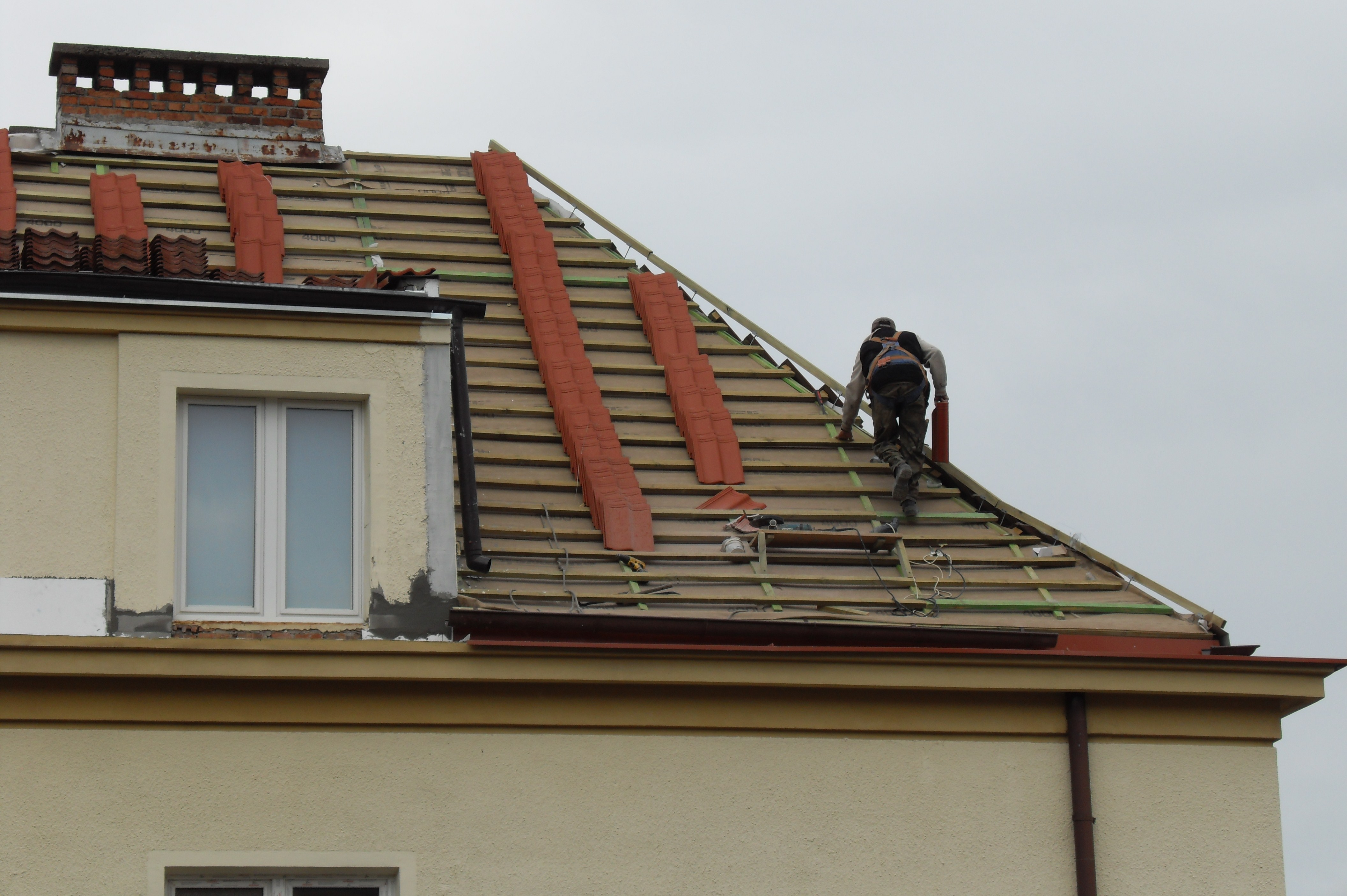 Artisan rénovant une toiture en tuiles